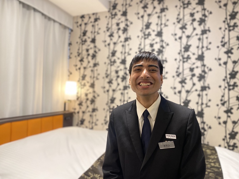 Smiling Karan in a hotel room in APA hotel
